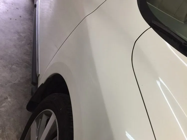 Paintless dent repair of a crease along a body feature line — after